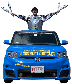 Flippo standing out of the hood of his blue car with his arms spread holding bowling pins for juggling